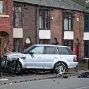 Range Rover Crashes Into Terraced House After Hitting Bus Stop in Bolton