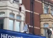 Girl dangles from window ledge above London shop before dramatic rescue